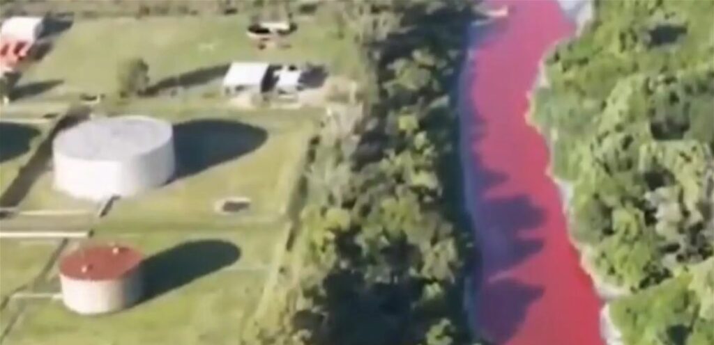 Red water invades a river in Argentina