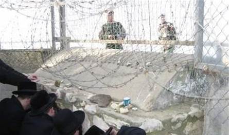 Settlers enter the grave of Abbad located within the Lebanese territories on the outskirts of Hala